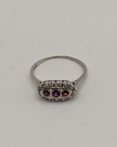 A 18ct white gold ring set with three rubies and diamonds 3g Location: