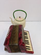 A mid century painted metal teapot and a Hohner piano accordion in a mottled red case Location: