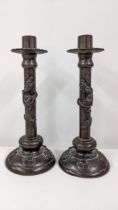 A pair of Asian patinated bronze candlesticks decorated with dragons Location: