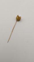 A yellow metal stick pin fashioned as foxes head inset with ruby eyes 7.5g Location: