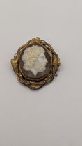 A Victorian gold plated Cameo mourning brooch depicting the bust of a man in a oval setting entwined