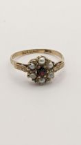 A 9ct gold ring set with a red garnet and pearls, 2.4g Location: