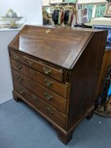 A Georgian mahogany bureau with a fall flap revealing a fitted interior with four graduating