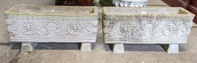 A pair of reconstituted stone garden trough planters having moulded Grecian style decoration, raised