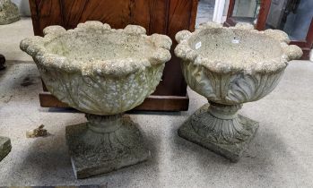 A pair of reconstituted stoneware garden planters having moulded left decoration and on square