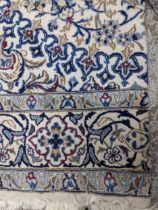 An Iranian Isfahan handwoven large carpet, part silk, floral decoration on a white ground with