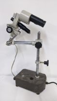 A Meiji techno watchmakers microscope on a stand Location: