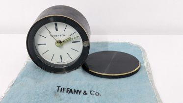 A Tiffany & Co. travel alarm clock in a gunmetal coloured case with rotating cover, numbered 12570