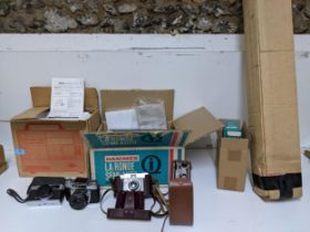 Vintage cameras, projectors, and a projector screen to include an Olympus Trip 35, leather cased