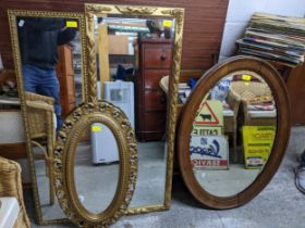 A group of four wall mirrors to include an 1930s oval oak framed example, a navette shaped gilt