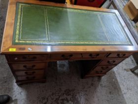 A modern yew wood twin pedestal desk, gilt tooled green leather insert to top, central frieze drawer