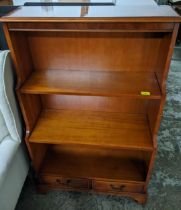 A late 20th century yew finished waterfall bookcase with two drawers Location: