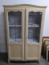 A painted display cabinet with twin leaded display doors, three white painted adjustable shelves, on