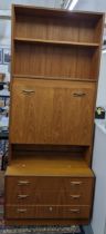 A mid 20th century retro G-Plan teak cabinet having open shelves, a fall flap and three drawers