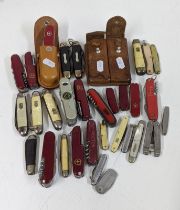 A variety of pocket knives to include Swiss Army style red utility pocket knives, together with