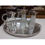 A silver plate on copper-oval gallery tray, two silver plated and cut glass claret jugs, one with
