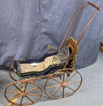 A late Victorian dolls pram having a wooden painted body and fringed canopy with metal supports