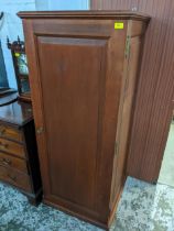 An imitation mahogany wardrobe of small proportions with cantilever hanging rail on plinth base,