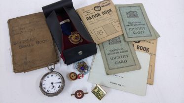 A mixed lot to include an open faced silver pocket watch, metals and badges including two silver