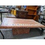 A contemporary pink stone coffee table, rectangular top with carved edge, standing on a square