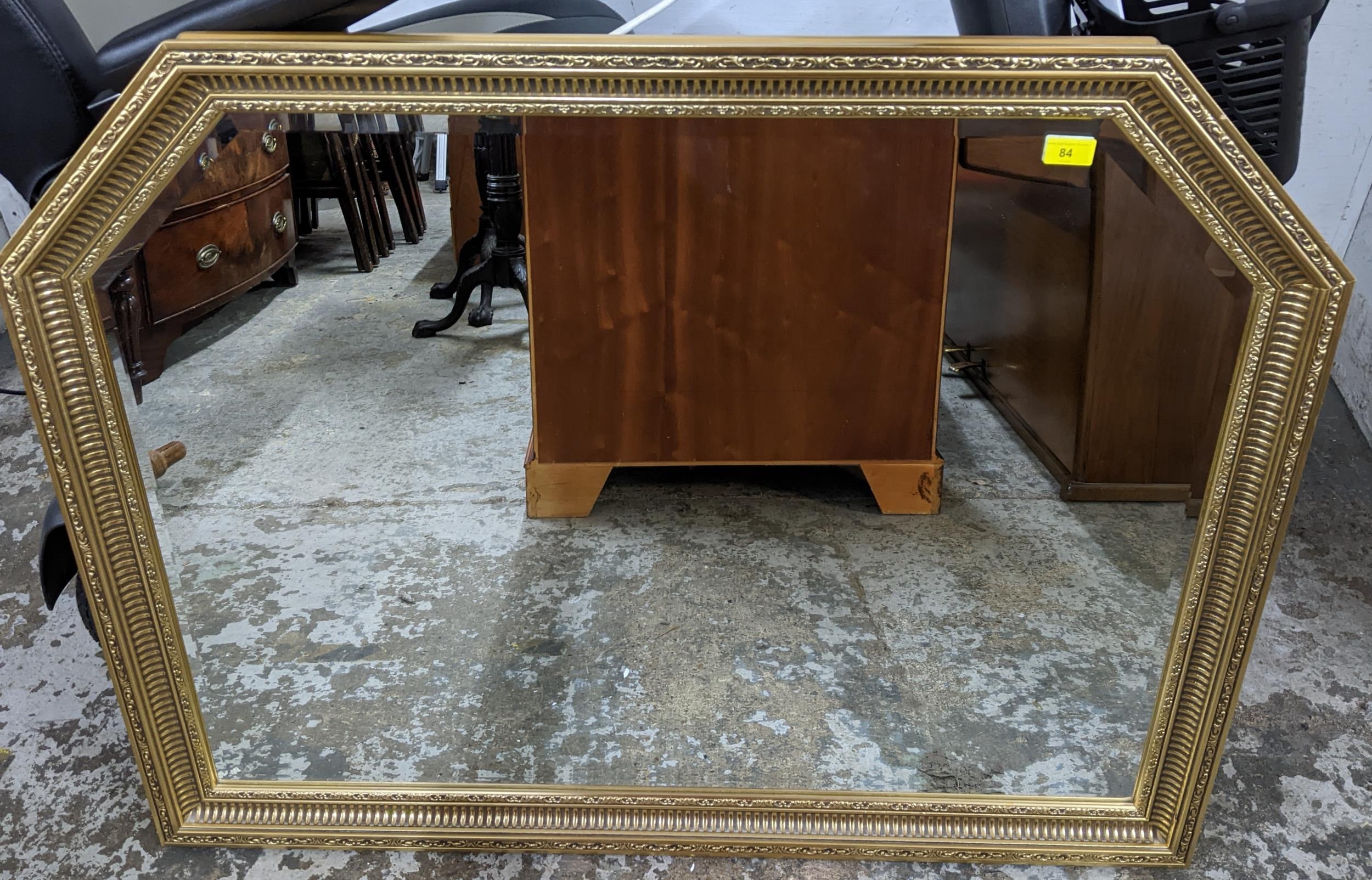 A contemporary gilt framed wall mirror with truncated top corners, bevelled glass plate 87.5 x113cms