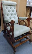 A late Victorian walnut rocking chair having a scroll work frame and on casters Location: