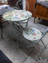 A sky blue painted metal folding garden table and two matching chairs, circular table top and