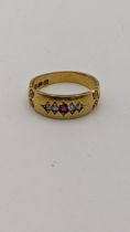 An 18ct gold ring set with a central ruby flanked by diamonds 4.4g Location: