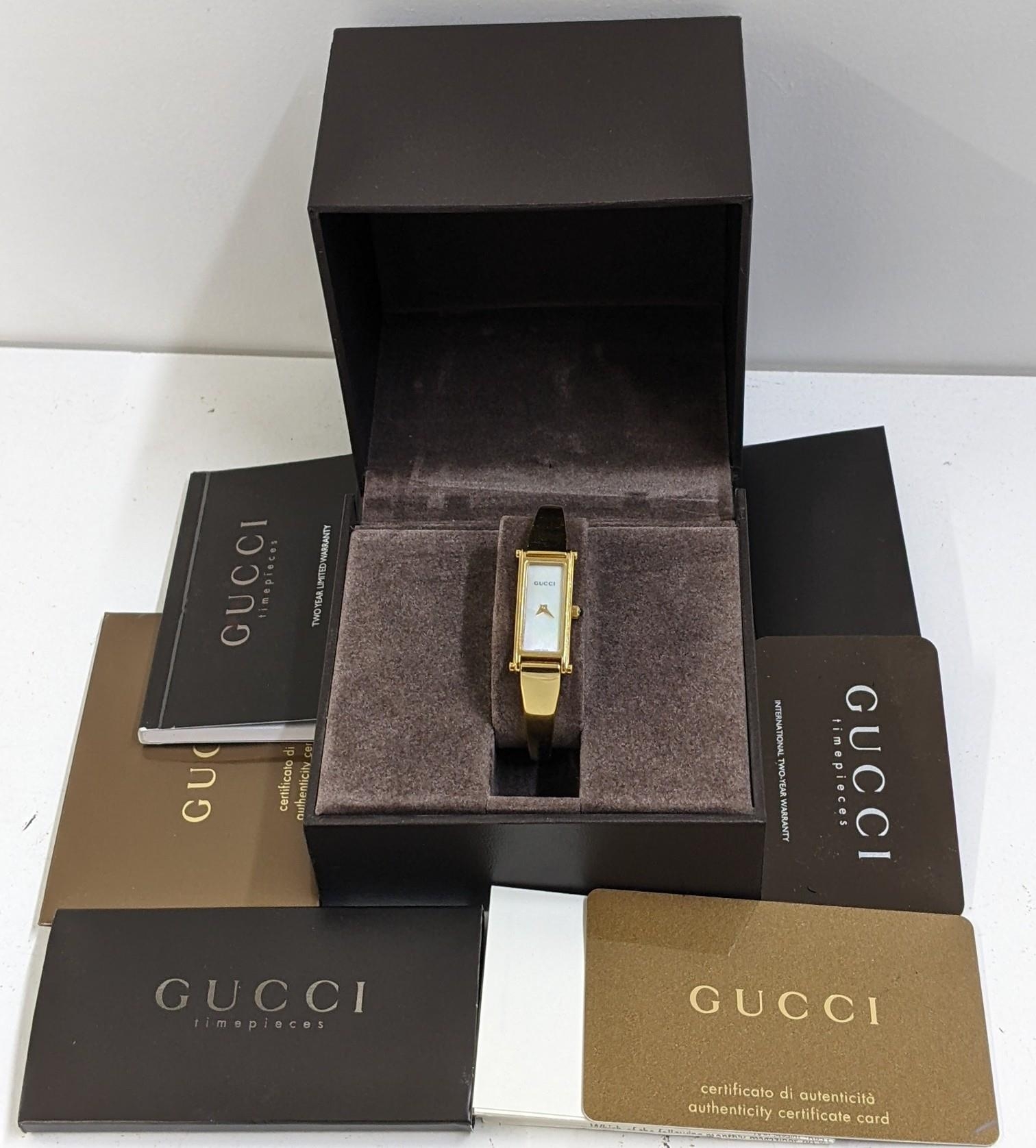 A boxed Gucci gold plated bangle wristwatch with a mother of pearl dial Location: