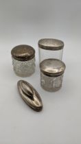 Three dressing table jars, one having floral engraved detail to its lid, Birmingham 1897, along with