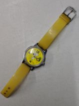 A Snoopy tennis unisex wristwatch with a quartz movement, yellow face, Arabic and baton dials on a