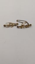 Two yellow metal bar brooches to include a yellow metal crescent moon and star brooch set with