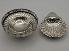 Two silver dishes, one with a pierced rim on a pedestal base and shell dish on ball feet,