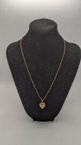 A yellow metal necklace, together with a gold plated locket fashioned as a heart 3.8g Location: