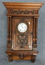 A late 19th century French Walnut 8 day wall clock, the case of architectural design and two train