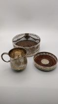 Two silver pierced wine coasters, along with a silver cup hallmarked London 1962, made by Garrard