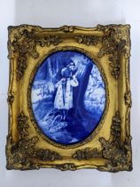 A blue and white oval porcelain plaque depicting two children hiding behind a tree in a woodland