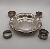 A white metal dish together with two silver and two white metal napkin rings, total weight, 167.1g