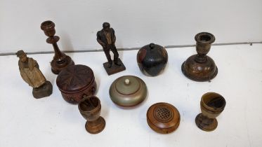 Treen to include two carved wooden figures, boxes, two candlesticks, and egg cups Location: