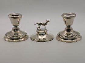 A pair of silver candlesticks and silver paperweight surmounted by a dog, combined weight 514.9g