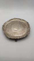 A three-footed silver card tray having engraved floral detail, hallmarked London 1874, 246.3g