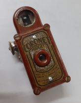 A Coronet Midget camera in a red casing Location: Cab