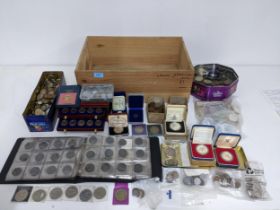 A wooden box containing a quantity of silver proof coins, commemorative coins, and worldwide