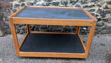 A 1960s Silkeborg Danish teak two tier trolley having black lacquered shelves and raised on castors,