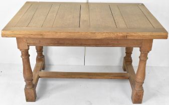 An early/mid 20th century Heals oak refectory extending dining table, having two slide out leaves,