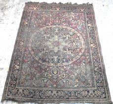 An Iranian Isfahan hand woven rug having a central motif on a red ground with geometric designs