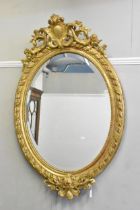 A late 19th century French oval gilded wall mirror, circa 1880, the frame having pierced angled