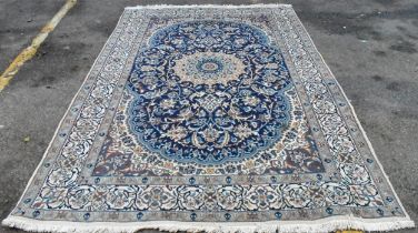 An Iranian Isfahan carpet having a central motif surrounded by a stylised floral decoration with