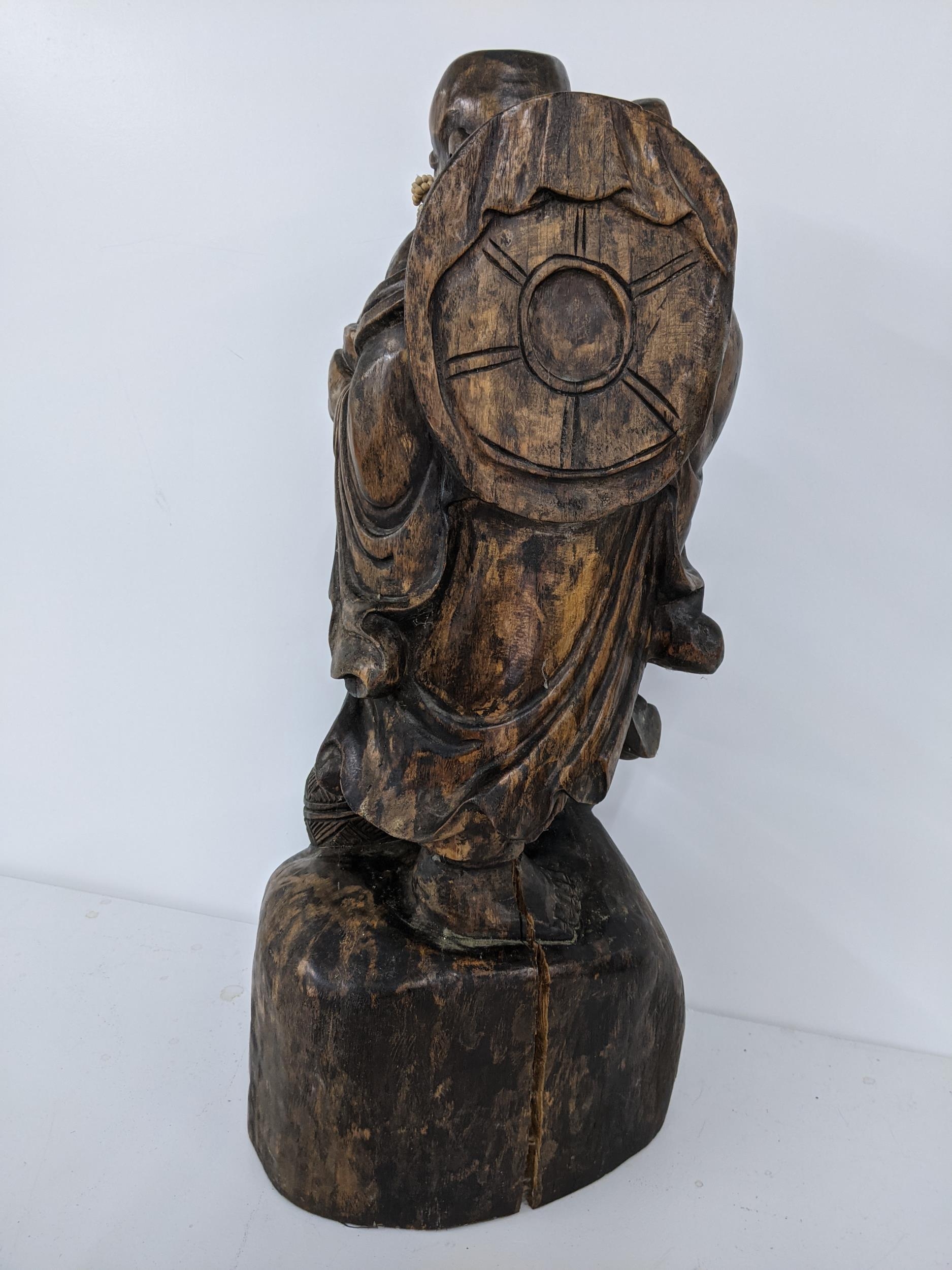 A Chinse treen carved figure of a smiling Buddha, holding a staff to one hand, 57.5h, Location: - Image 4 of 4