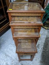 A Chinese quartetto nest of tables with carved panel and glass inset tops, the largest 66.5m x 50.